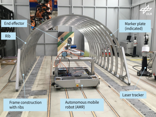 Maqueta de la estructura del fuselaje de un avión con robot móvil, incluyendo inscripciones.