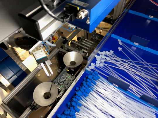 Un robot clasifica catéteres con accesorios azules y blancos utilizando una cámara Ensenso 3D.