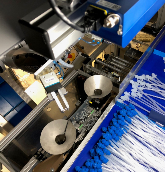 Un robot clasifica catéteres con accesorios azules y blancos utilizando una cámara Ensenso 3D.