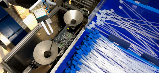 Un robot clasifica catéteres con accesorios azules y blancos utilizando una cámara Ensenso 3D.
