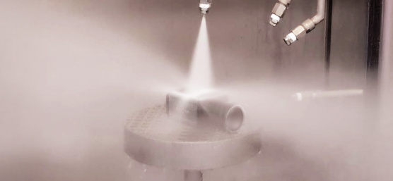 La cámara industrial se expone a fuertes chorros de agua por todos los lados en una instalación de pulverización.