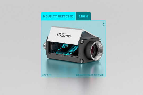 IDS NXT con carcasa abierta, con «AI» en letras de neón. Cámara en un marco azul y las letras «novedad detectada 100%».