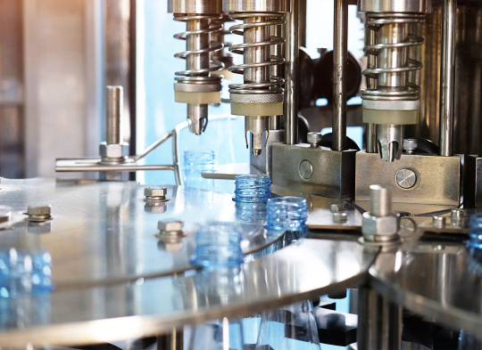 La máquina cierra botellas automáticamente en el sistema de agarre giratorio.