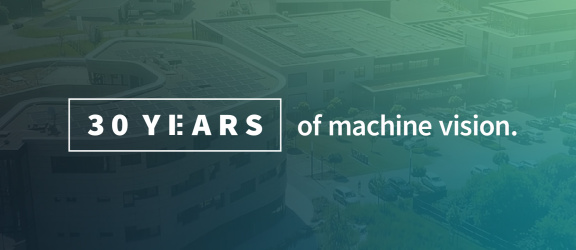 Degradado de color gris y verde con la inscripción: «30 years of machine vision»