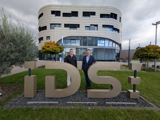 El ganador del premio Jonas Gaißer y el profesor Dr. Ing. Heiko Thimm delante del edificio de la empresa IDS.
