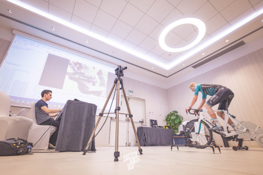 Gran sala con un ciclista al que se examina con una cámara el pedaleo y el ángulo articular