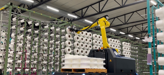 El sistema de asistencia robótica de conducción autónoma con cámara Ensenso 3 D permite la carga automatizada de las filetas con bobinas de hilo.