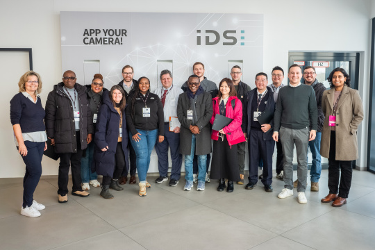 Grupo de visitantes del programa MIT REAP durante su estancia en IDS delante de un muro con la marca.