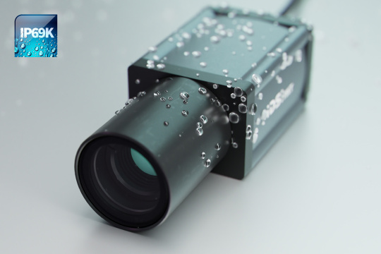 Cámara IDS NXT con IA con lente y gotas de agua en la carcasa e icono IP69K