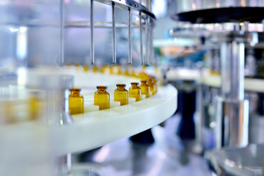 Viales de medicamentos pasan por una máquina