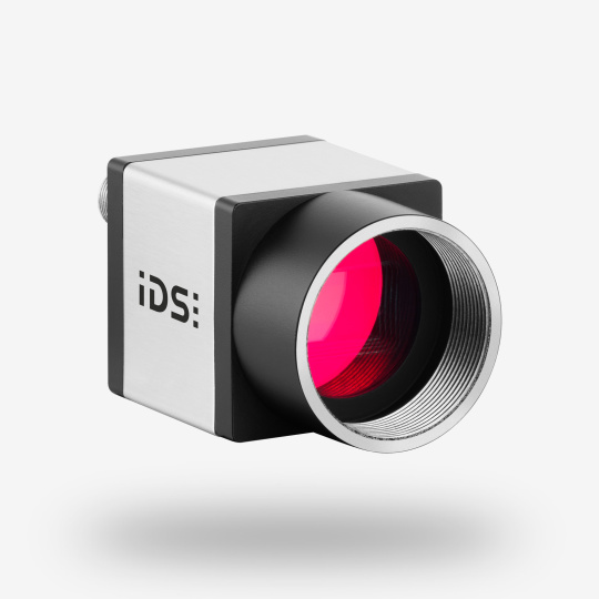 Cámara industrial IDS uEye CP vista frontal angular con logotipo IDS.