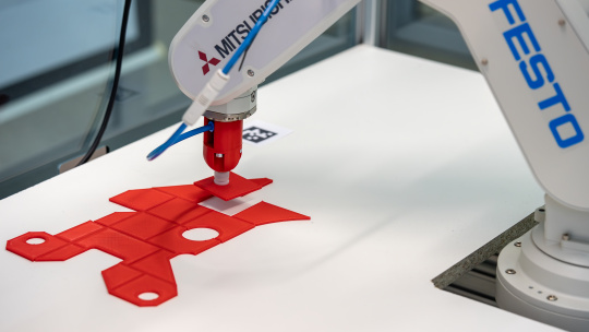 El brazo del robot coloca el componente en la posición especificada.